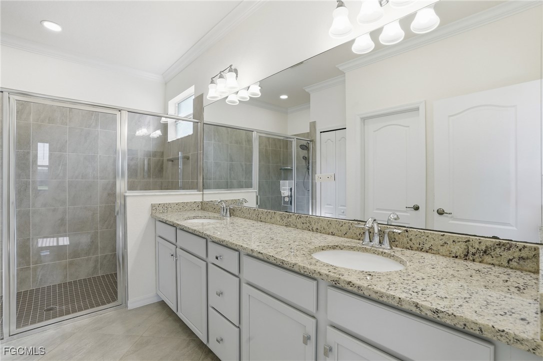 2251 Dancy Street Naples, FL 34120 - Photo 13 of 28 a bathroom with a granite countertop double vanity sink and shower