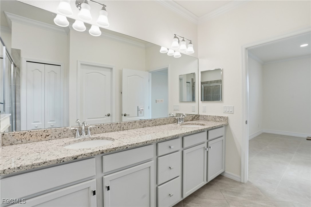 2251 Dancy Street Naples, FL 34120 - Photo 14 of 28 a bathroom with double vanity sinks a vanity a lamp and a mirror