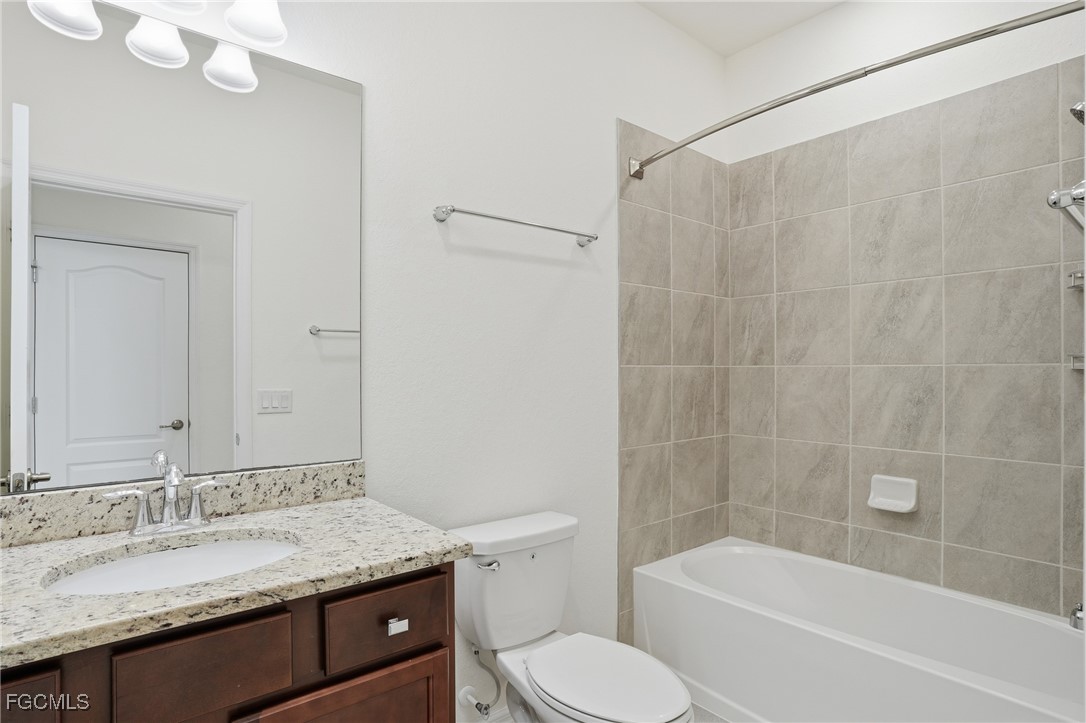 2251 Dancy Street Naples, FL 34120 - Photo 18 of 28 a bathroom with a granite countertop sink toilet and shower