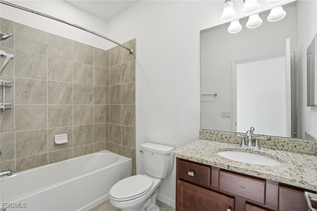2251 Dancy Street Naples, FL 34120 - Photo 24 of 28 a bathroom with a granite countertop sink a toilet and bathtub