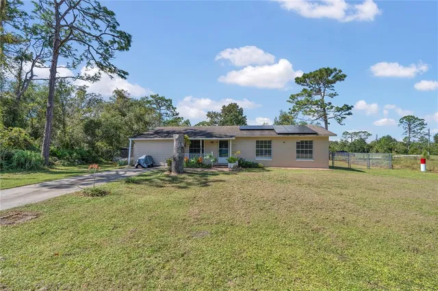 a view of a house with backyard and sitting area