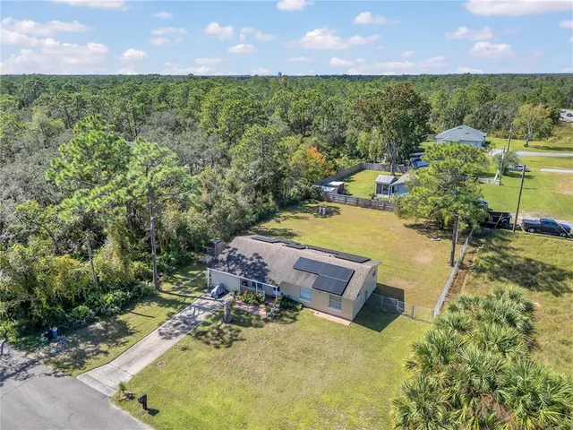 an aerial view of a house with a yard and lake view