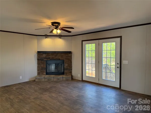 a view of an empty room with a fireplace and a window