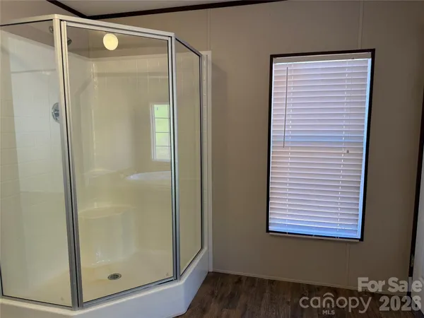 a bathroom with a glass shower door and a window