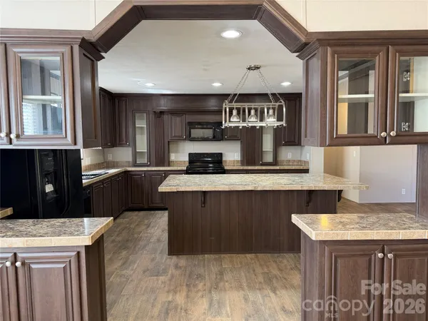 a kitchen with kitchen island granite countertop wooden cabinets and a sink