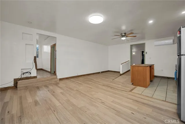 a view of an empty room with a window and a kitchen