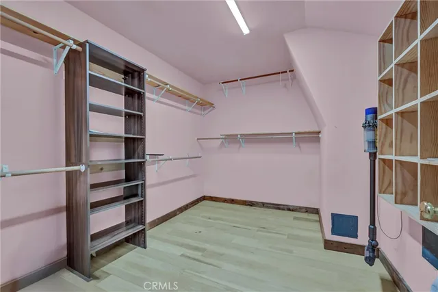 a view of a room with wooden floor and ceiling fan