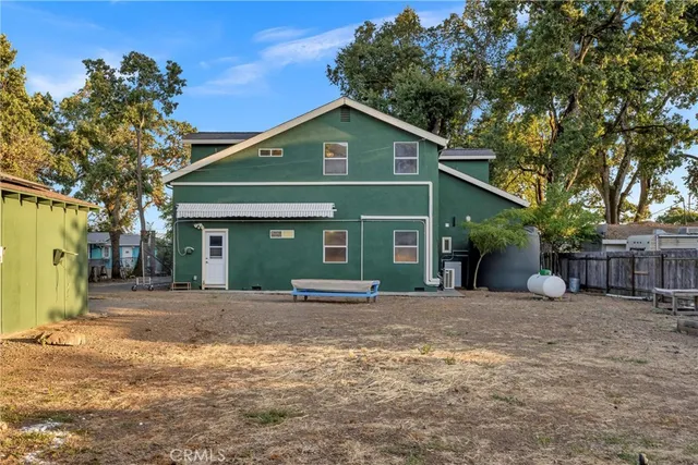 a view of house with backyard and trees