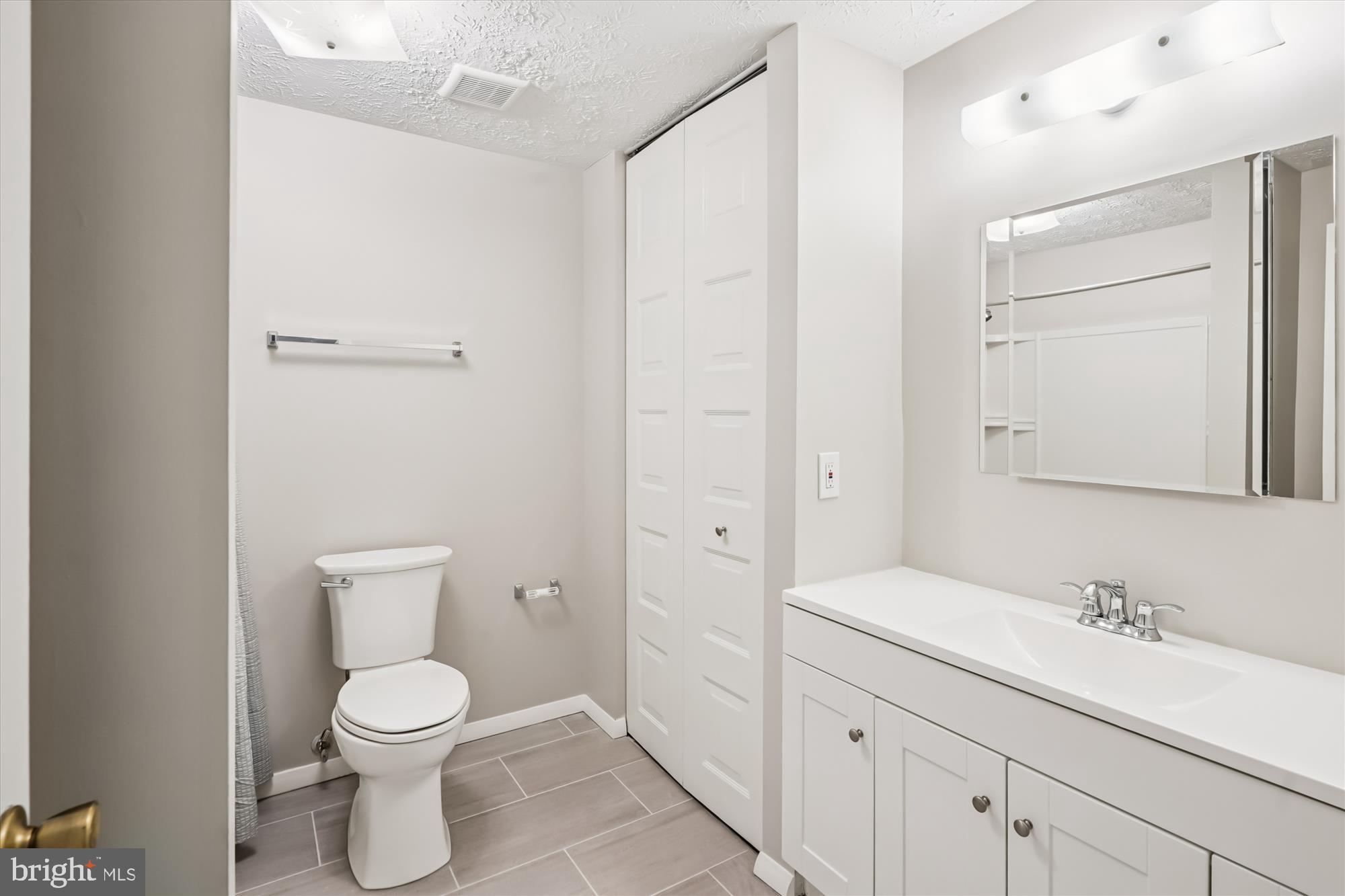 135 Applegate Drive Sterling, VA 20164 - Photo 15 of 42 a bathroom with a toilet a sink a mirror and vanity