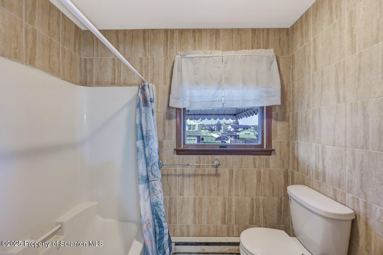 309 Lowery Street Scranton, PA 18505 - Photo 40 of 65 a bathroom with a toilet and a shower curtain
