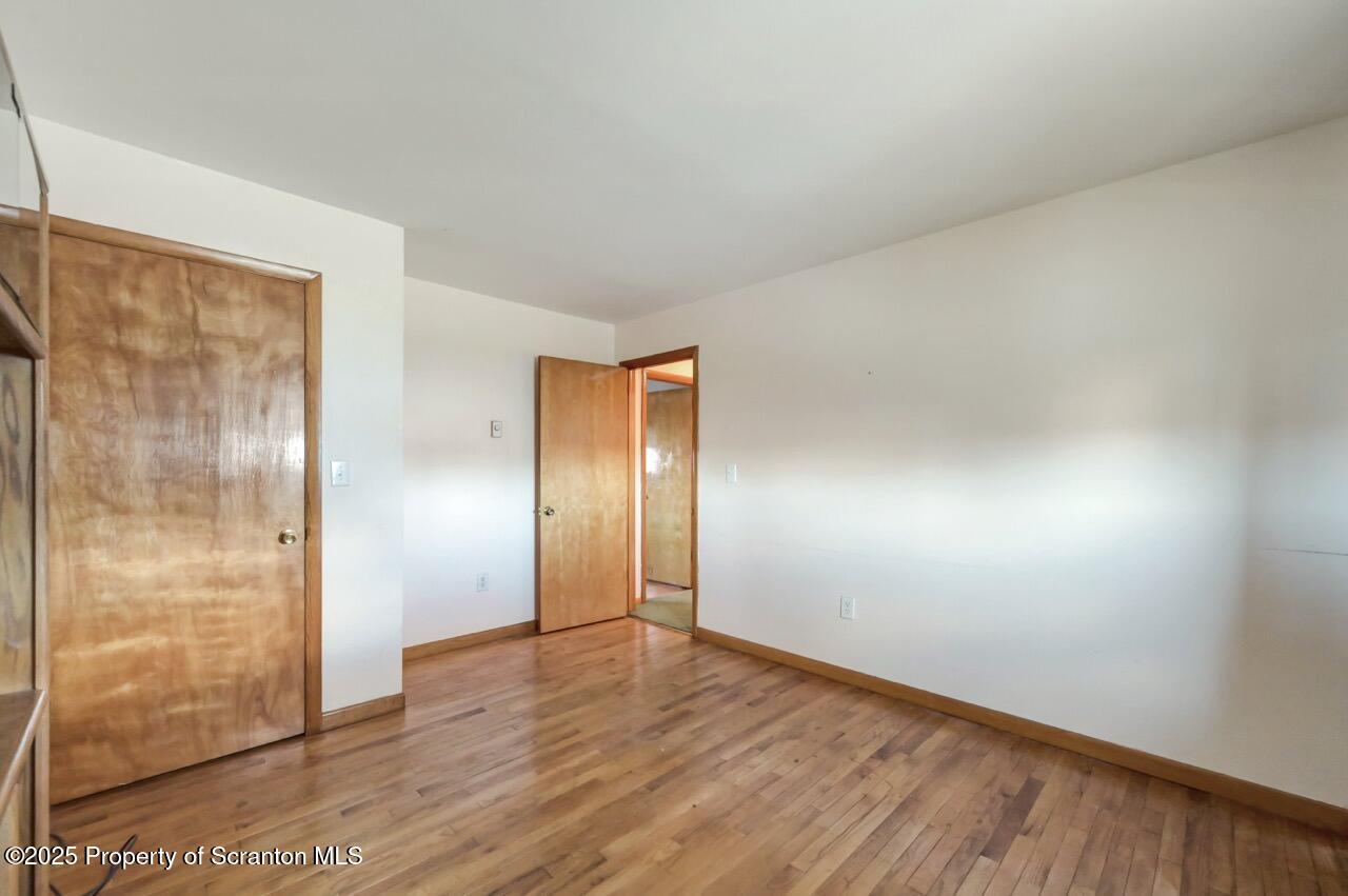 309 Lowery Street Scranton, PA 18505 - Photo 44 of 65 a view of an empty room with wooden floor and a bathroom
