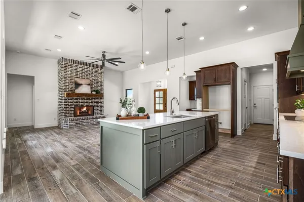 a kitchen with stainless steel appliances kitchen island granite countertop a sink stove and refrigerator