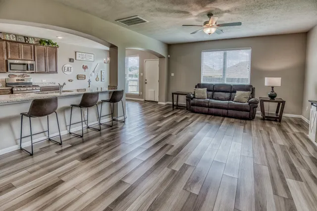 a living room with furniture and a wooden floor