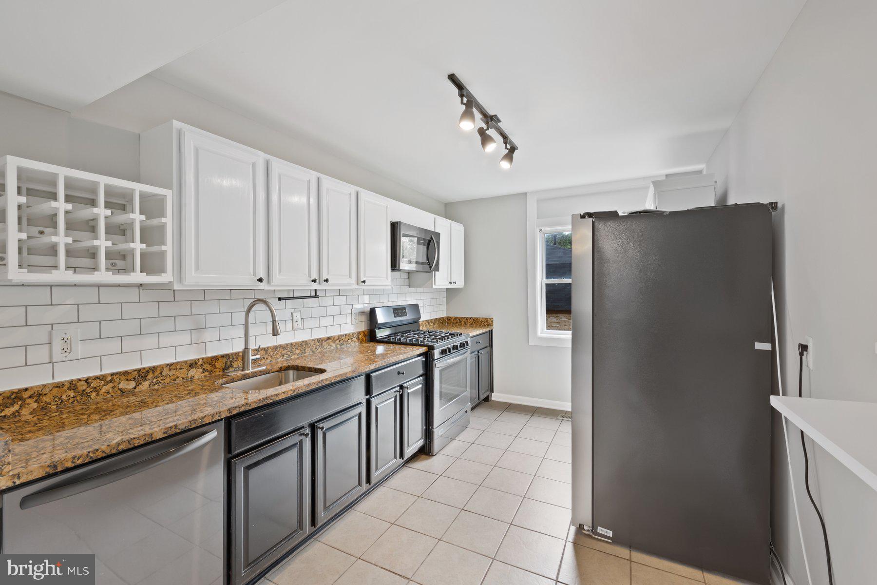 12537 Basque Place Woodbridge, VA 22192 - Photo 11 of 38 a kitchen with stainless steel appliances granite countertop a refrigerator and a sink