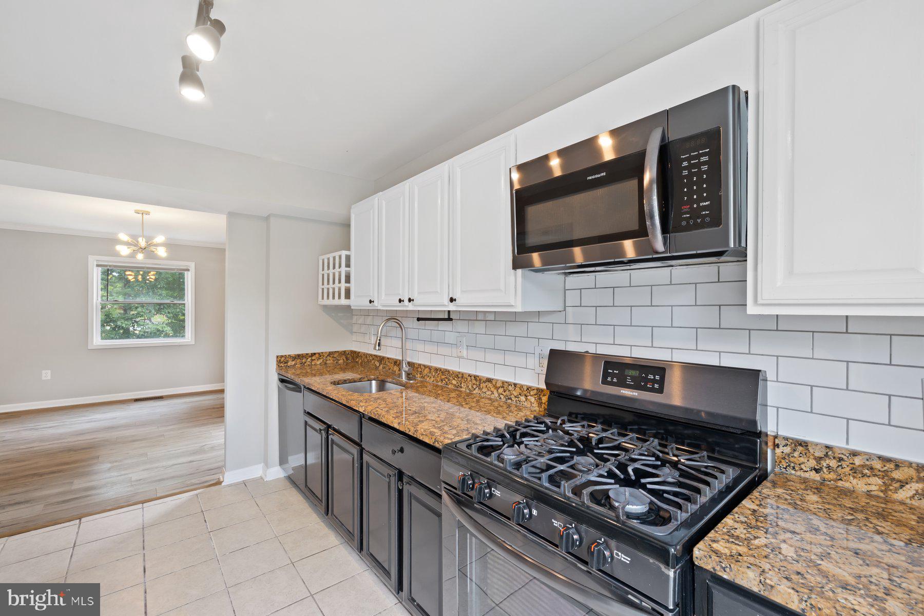 12537 Basque Place Woodbridge, VA 22192 - Photo 12 of 38 a kitchen with stainless steel appliances granite countertop a stove and a microwave