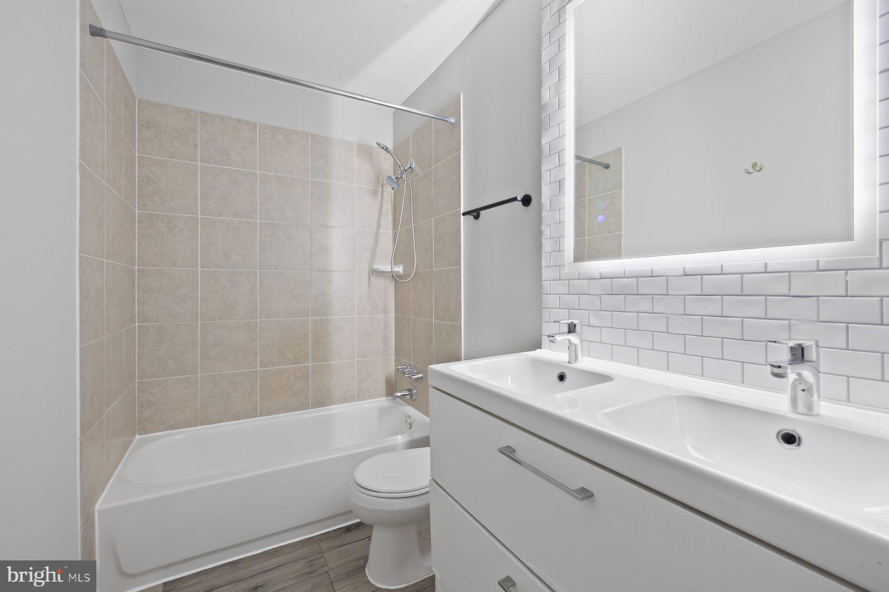 12537 Basque Place Woodbridge, VA 22192 - Photo 20 of 38 a bathroom with a bathtub shower sink vanity mirror and toilet