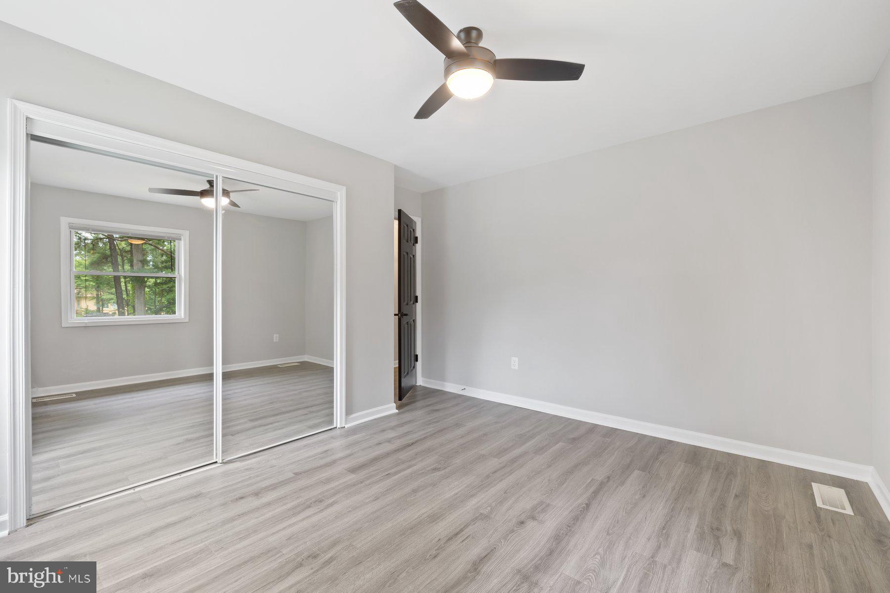 12537 Basque Place Woodbridge, VA 22192 - Photo 21 of 38 an empty room with wooden floor closet and windows