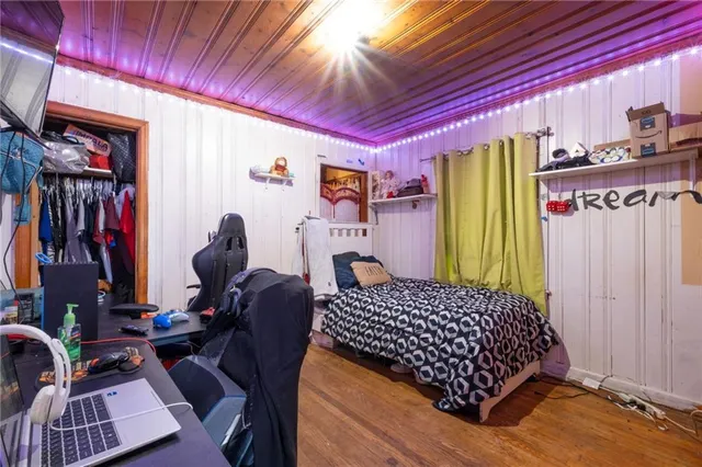 a bedroom with a bed and wooden floor