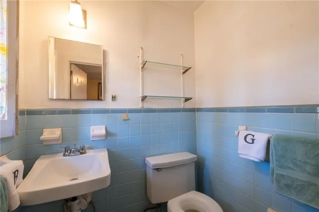 a bathroom with a toilet sink and mirror
