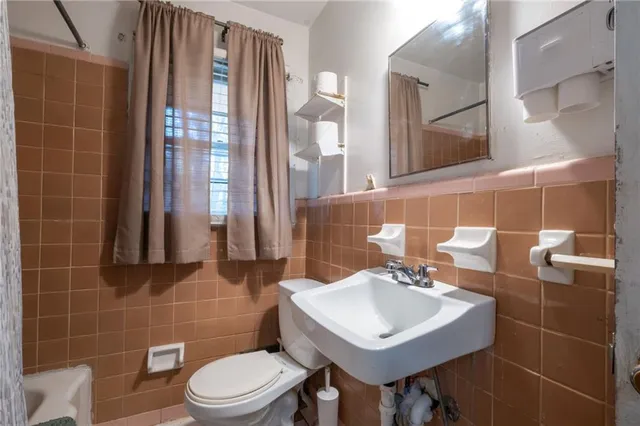 a bathroom with a sink toilet and mirror