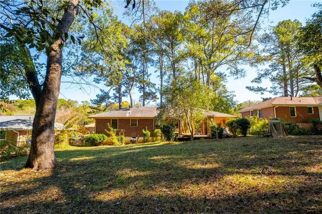 a view of a white house with a big yard and large trees