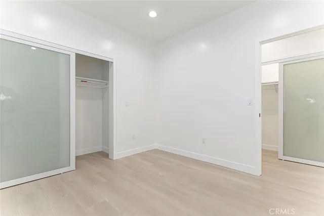 an empty room with windows and closet