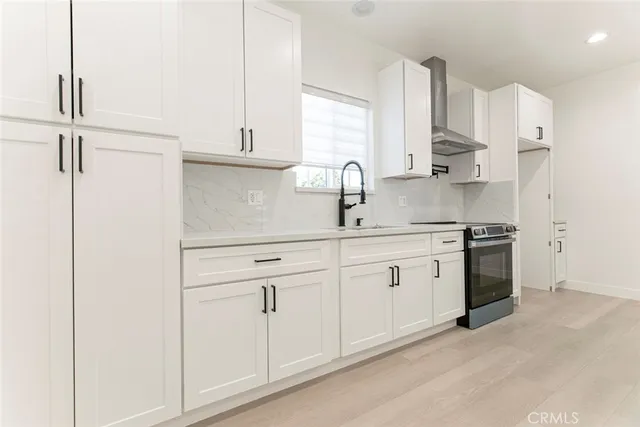 a kitchen with stainless steel appliances white cabinets and a sink