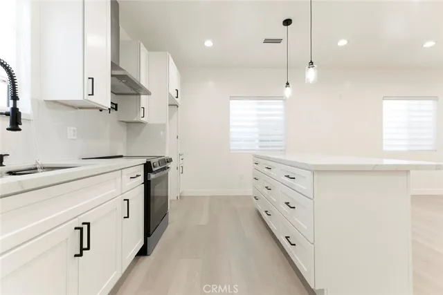 a kitchen with white cabinets and window