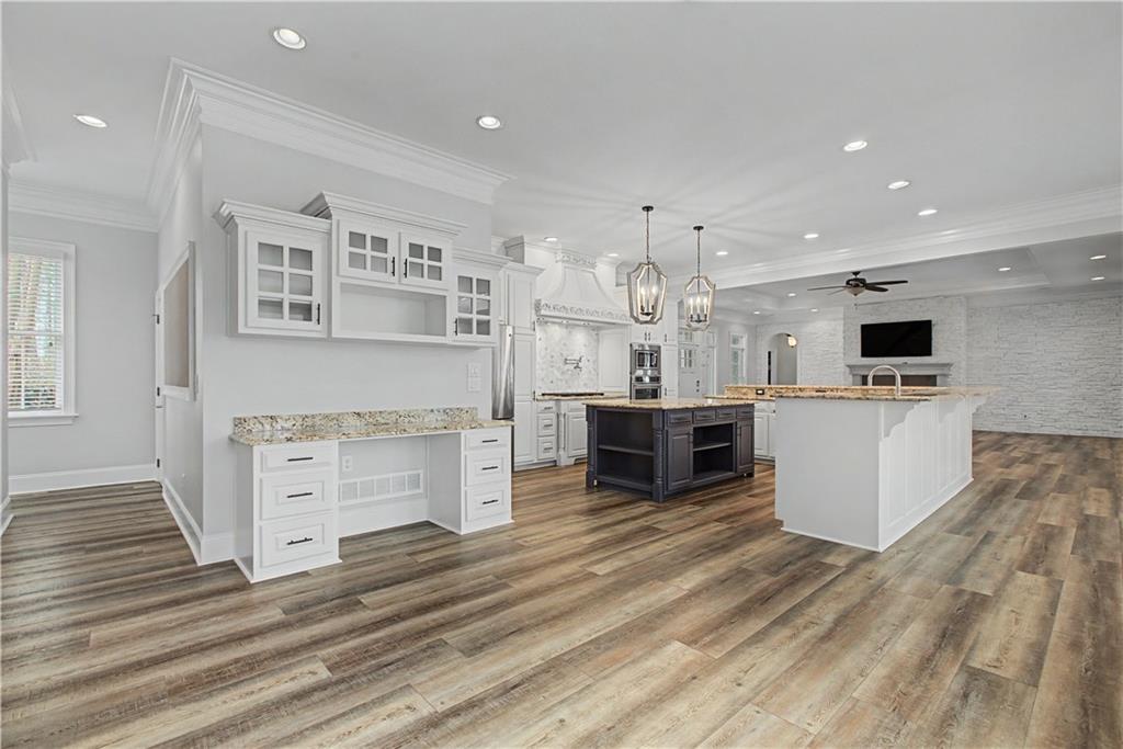 3045 Camp Branch Road Buford, GA 30519 - Photo 11 of 76 a large white kitchen with cabinets and wooden floor