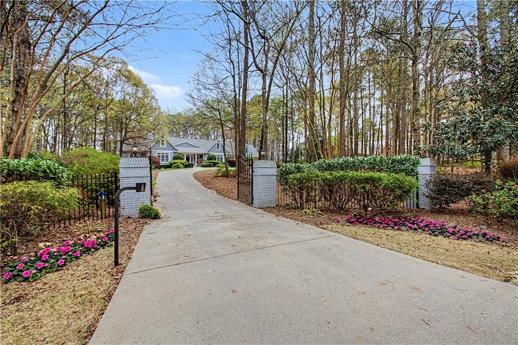 3045 Camp Branch Road Buford, GA 30519 - Photo 2 of 76 a view of a street with flower plants and large trees