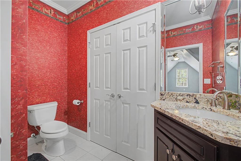 3045 Camp Branch Road Buford, GA 30519 - Photo 41 of 76 a bathroom with a granite countertop sink a toilet and a mirror