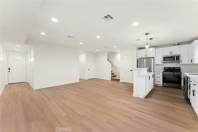 a view of kitchen with kitchen island and stainless steel appliances