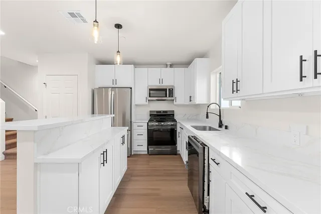 a kitchen with cabinets stainless steel appliances and a counter space
