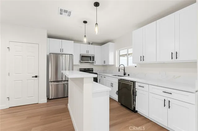 a kitchen with white cabinets and stainless steel appliances