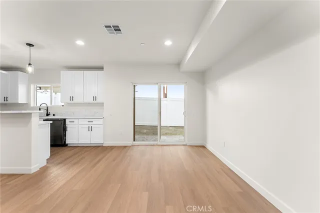 a view of a kitchen with wooden floor and a window