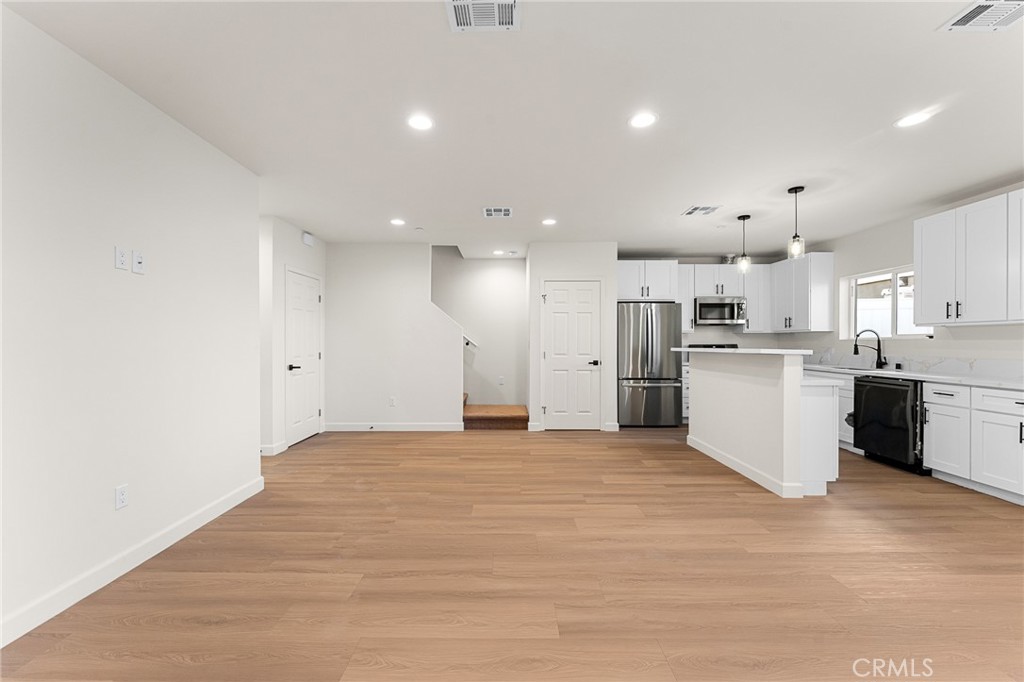 902 South Hert Street Colton, CA 92324 - Photo 10 of 34 a view of a kitchen with kitchen island a sink wooden floor and stainless steel appliances