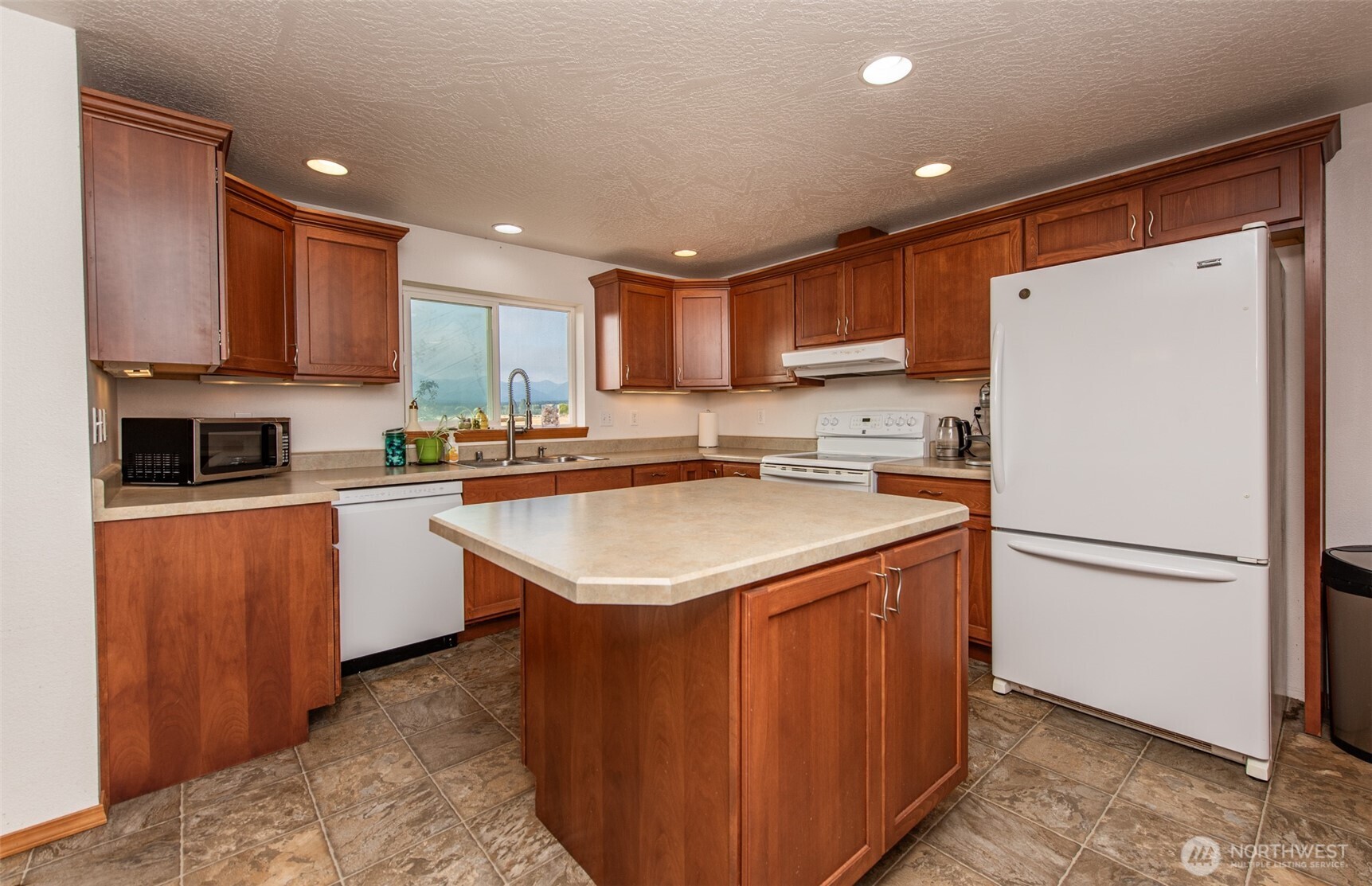 60 Ridge Place Sequim, WA 98382 - Photo 6 of 40 a kitchen with stainless steel appliances granite countertop a refrigerator a sink a stove a microwave and cabinets