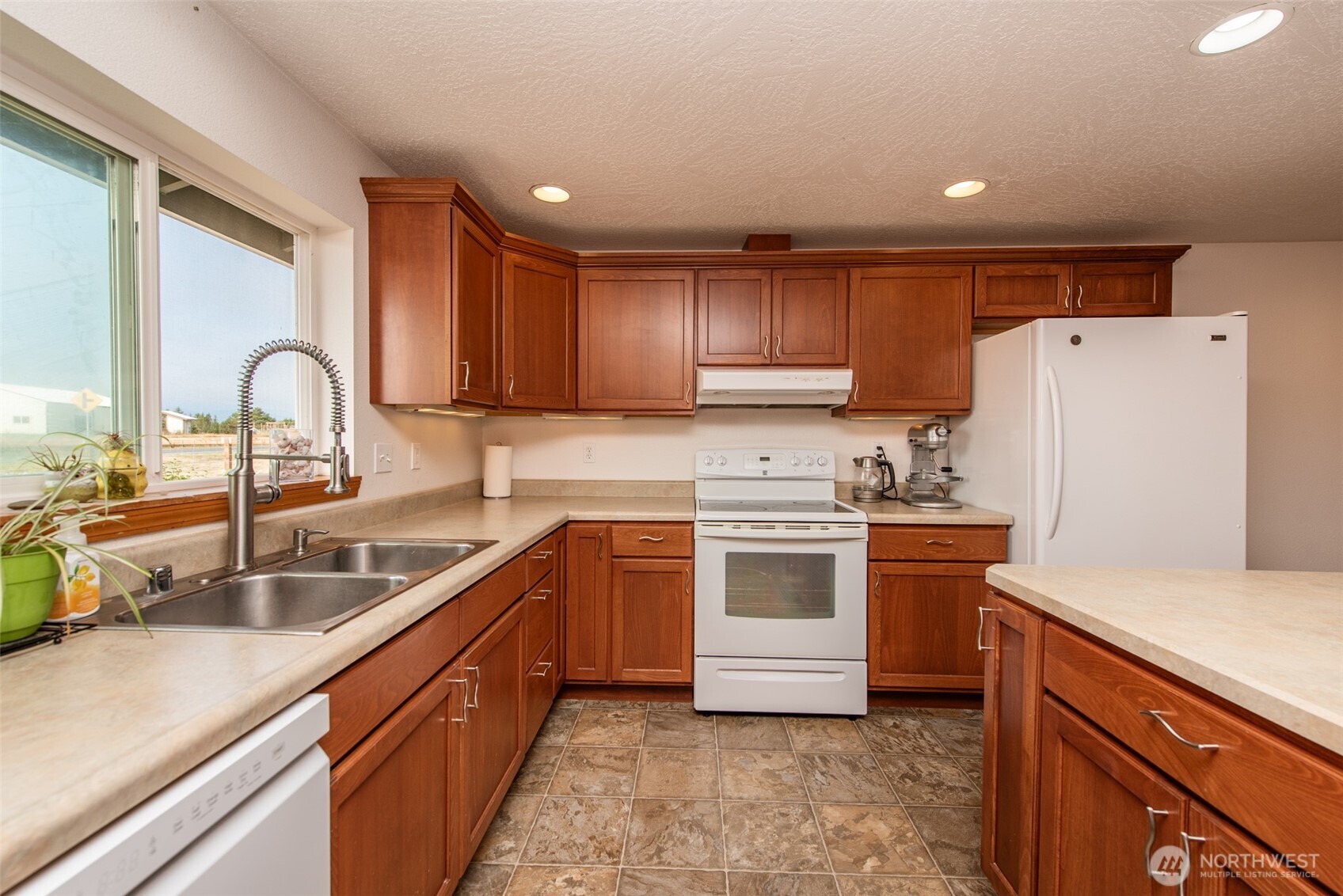 60 Ridge Place Sequim, WA 98382 - Photo 10 of 40 a kitchen with a refrigerator sink and white cabinets