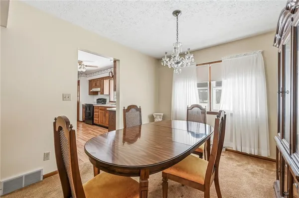 a dining room with furniture a chandelier and wooden floor