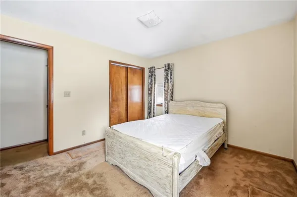 a bed room with a bed and a refrigerator