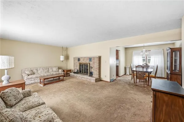 a living room with furniture and a dining table with kitchen view
