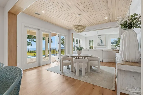 a dining room with furniture a chandelier and wooden floor