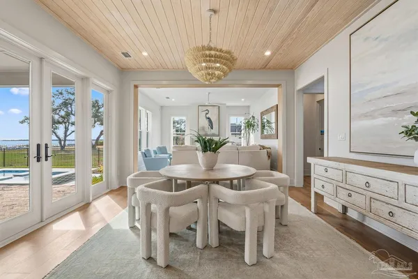 a view of a dining room with furniture large windows and wooden floor