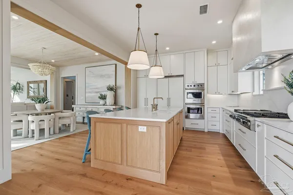 a kitchen with stainless steel appliances granite countertop a sink a stove and a refrigerator