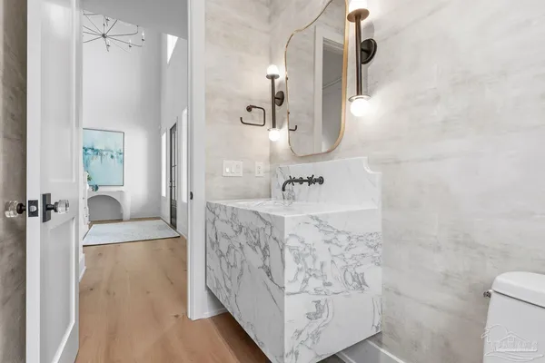 a bathroom with a toilet sink vanity tub and mirror