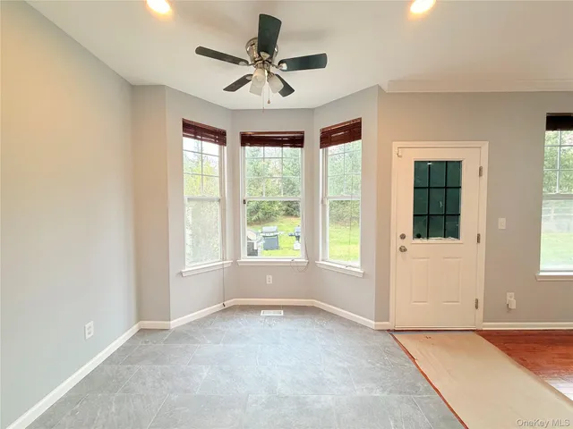a view of a livingroom with a ceiling fan and window