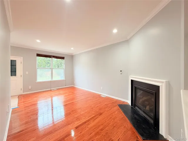 a view of an empty room with window and fire place