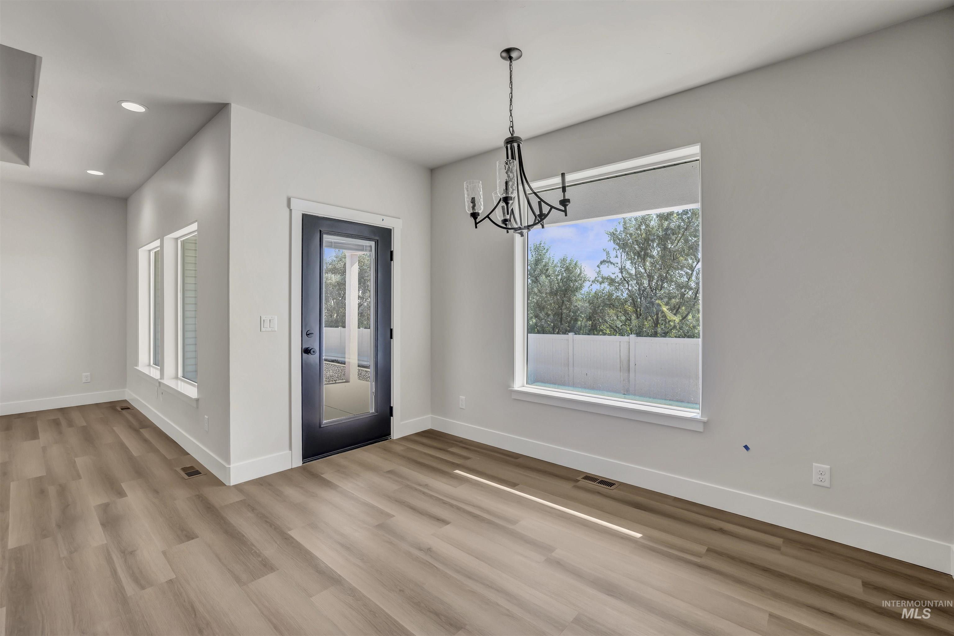941 Gregory Way Twin Falls, ID 83301 - Photo 13 of 40 Unfurnished dining area with a chandelier, light wood-style floors, healthy amount of natural light, and recessed lighting