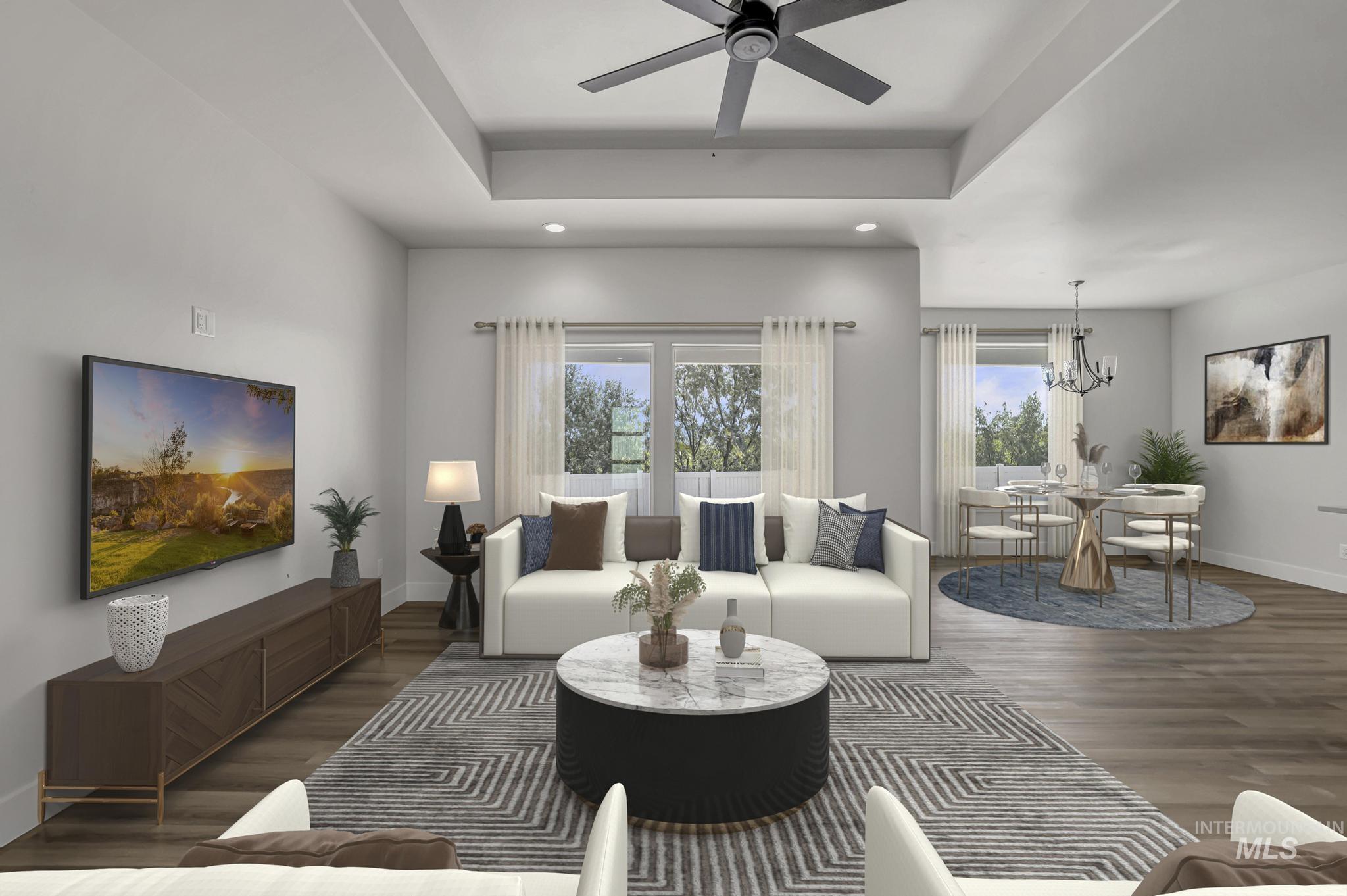 941 Gregory Way Twin Falls, ID 83301 - Photo 4 of 40 Living area featuring dark wood finished floors, a tray ceiling, ceiling fan, and a chandelier