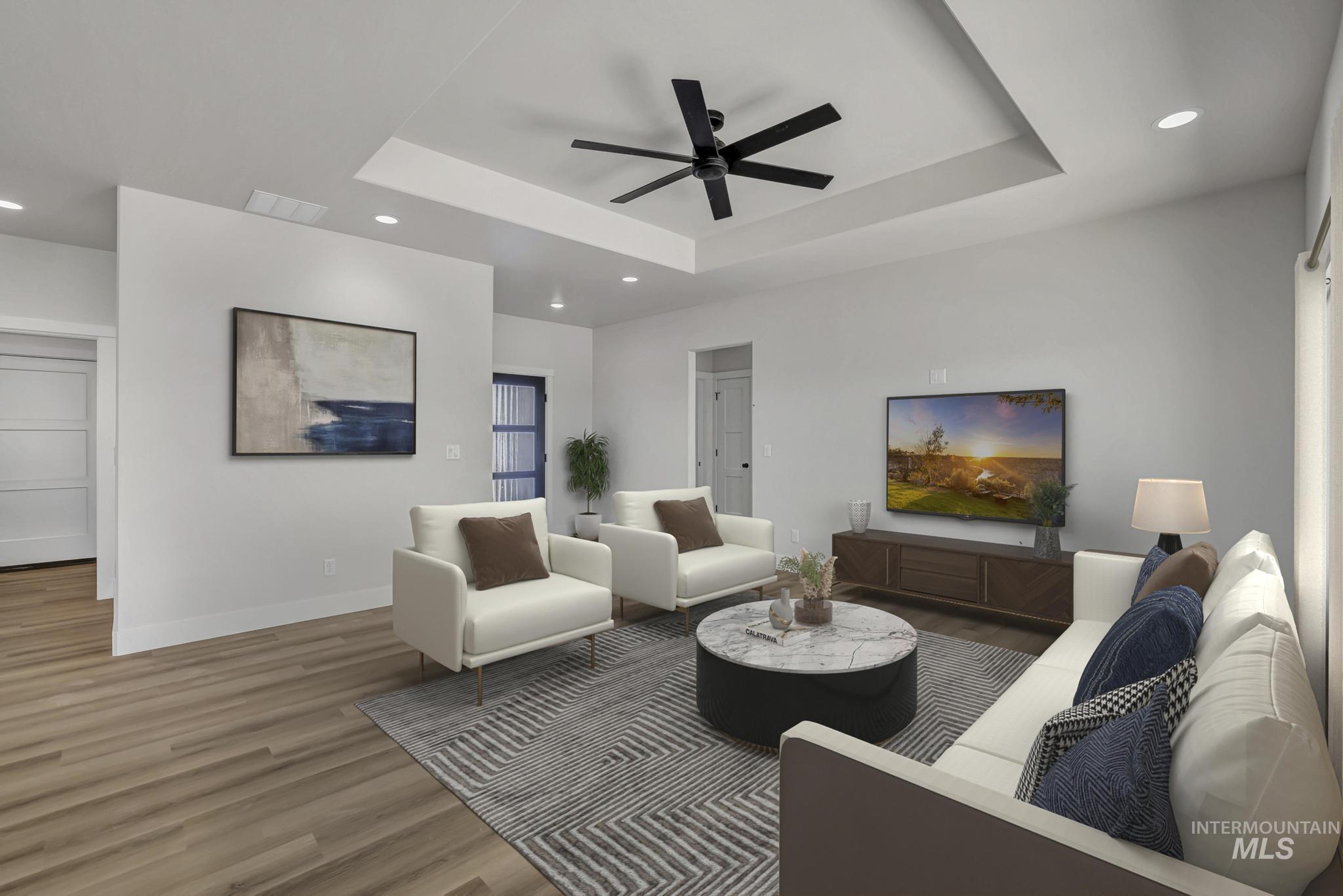 941 Gregory Way Twin Falls, ID 83301 - Photo 6 of 40 Living room with recessed lighting, a ceiling fan, wood finished floors, and a tray ceiling